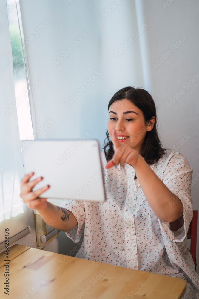 Chica joven risueña guapa interactuando con una tablet Chica joven risueña guapa interactuando con una tablet
