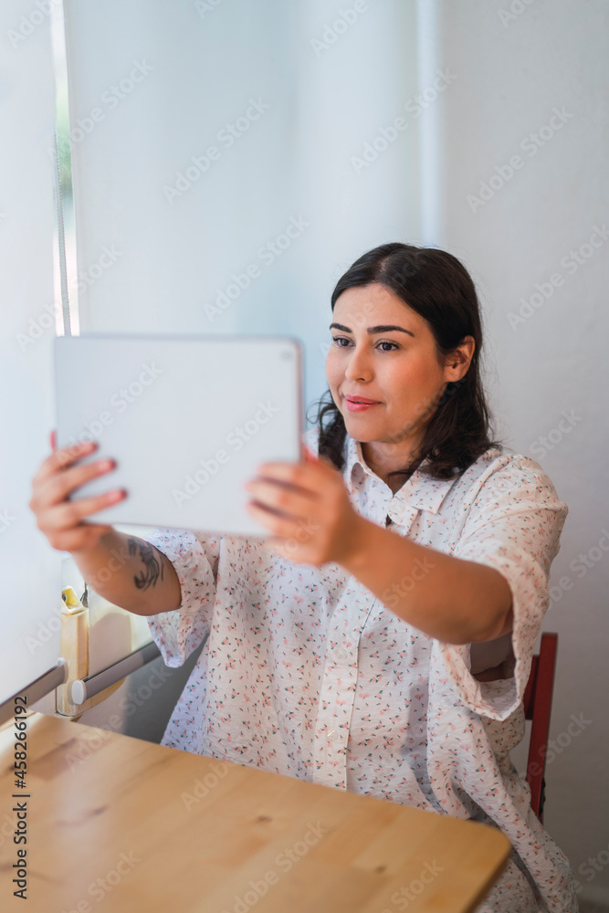 Chica joven risueña guapa interactuando con una tablet Chica joven risueña guapa interactuando con una tablet
