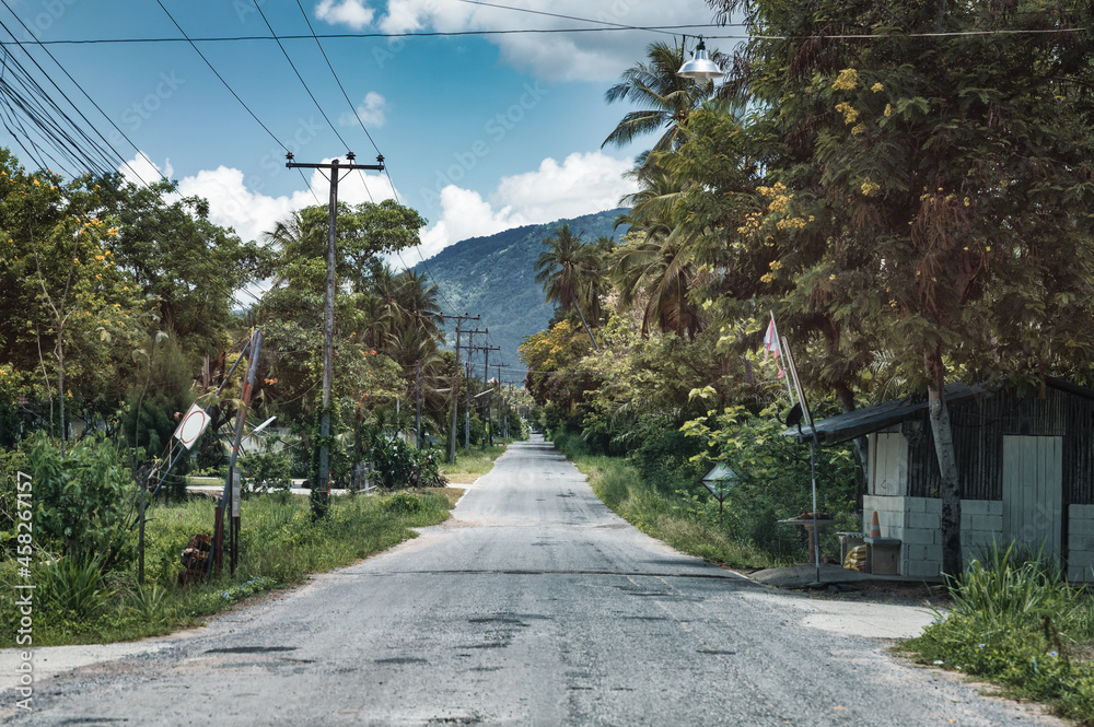 Straight asphalt road in the rainforest with hill on suburban