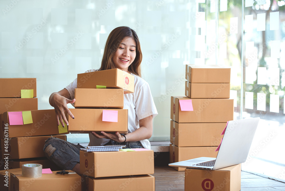 Small start-up business owners using computers at work, freelancers, saleswoman, checking production orders. Pack products for delivery to customers Small start-up business owners using computers at work, freelancers, saleswoman, checking production orders. Pack products for delivery to customers