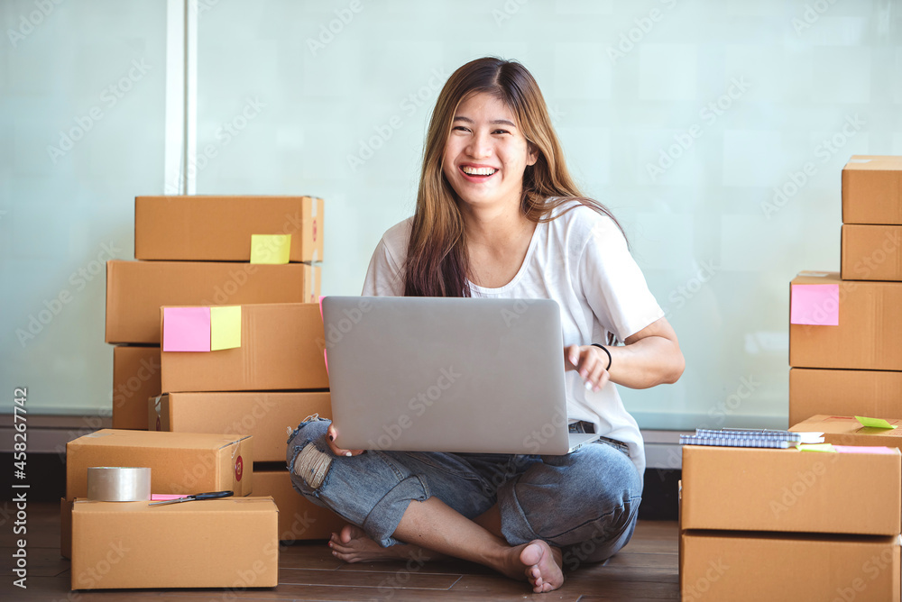 Small start-up business owners using computers at work, freelancers, saleswoman, checking production orders. Pack products for delivery to customers Small start-up business owners using computers at work, freelancers, saleswoman, checking production orders. Pack products for delivery to customers