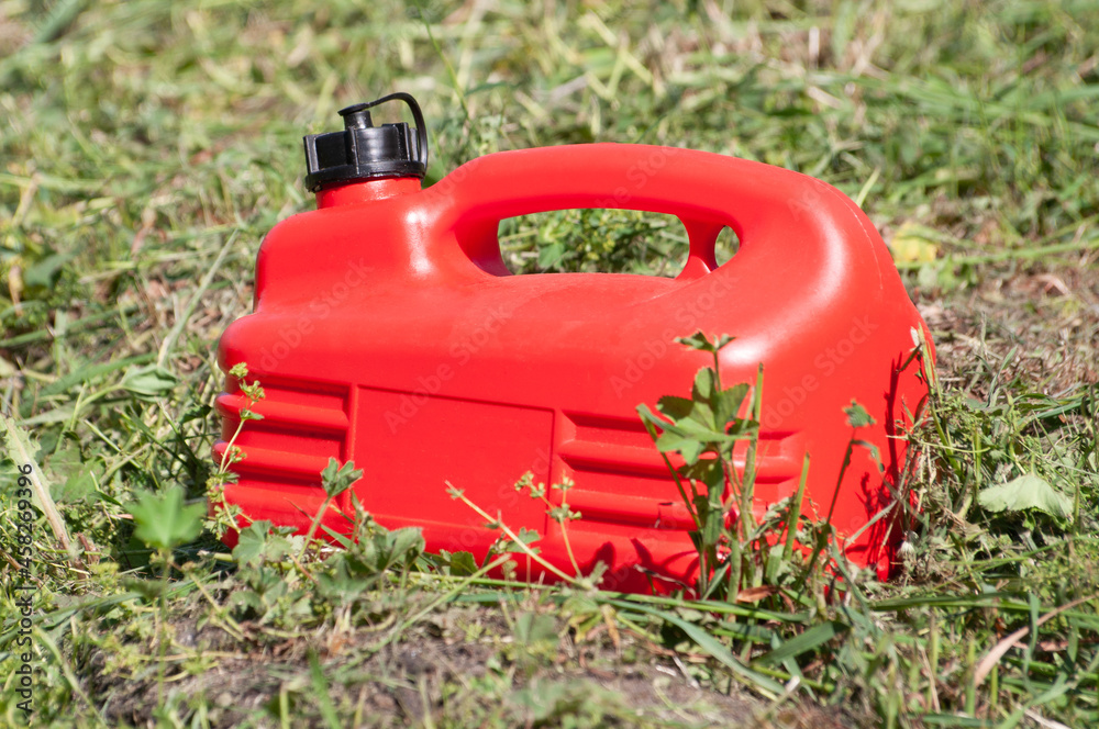 a red plastic gas canister among the green grass a red plastic gas canister among the green grass