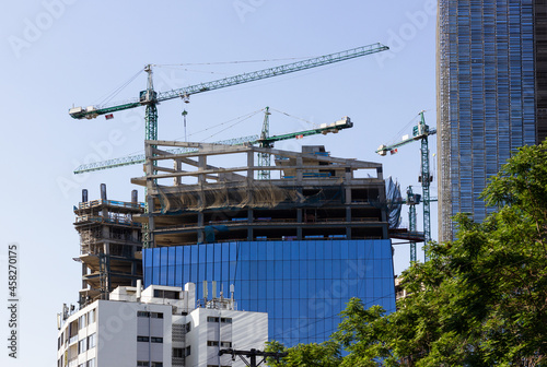 Modern building in construction with cranes in Santiago city, Chile. Engineering, urban development concepts photo