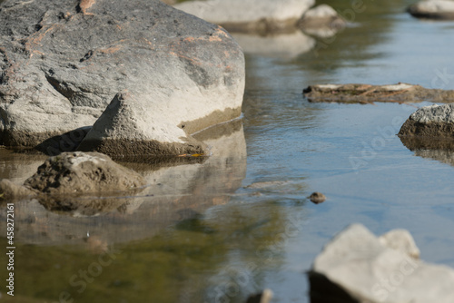 river stones with sky reflection