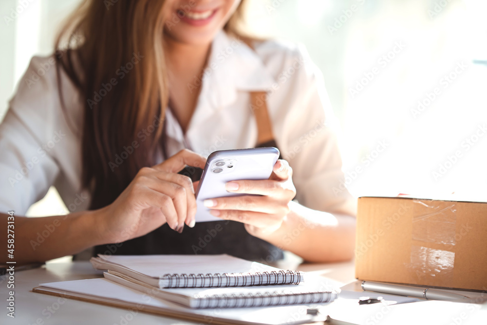 Small start-up business owners using computers at work, freelancers, saleswoman, checking production orders. Pack products for delivery to customers Small start-up business owners using computers at work, freelancers, saleswoman, checking production orders. Pack products for delivery to customers