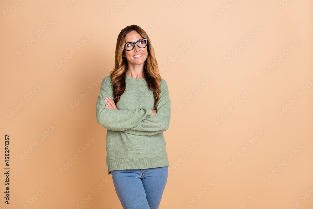 Photo portrait woman wearing glasses smiling crossed hands looking copyspace dreamy isolated pastel beige color background Photo portrait woman wearing glasses smiling crossed hands looking copyspace dreamy isolated pastel beige color background