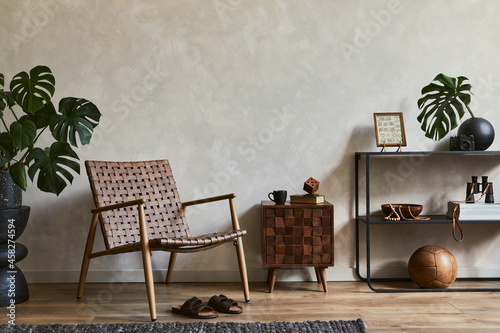 Fotografía Creative interior composition of elegant masculine living room with copy space, brown armchair, designed commode, industrial shelf and personal accessories