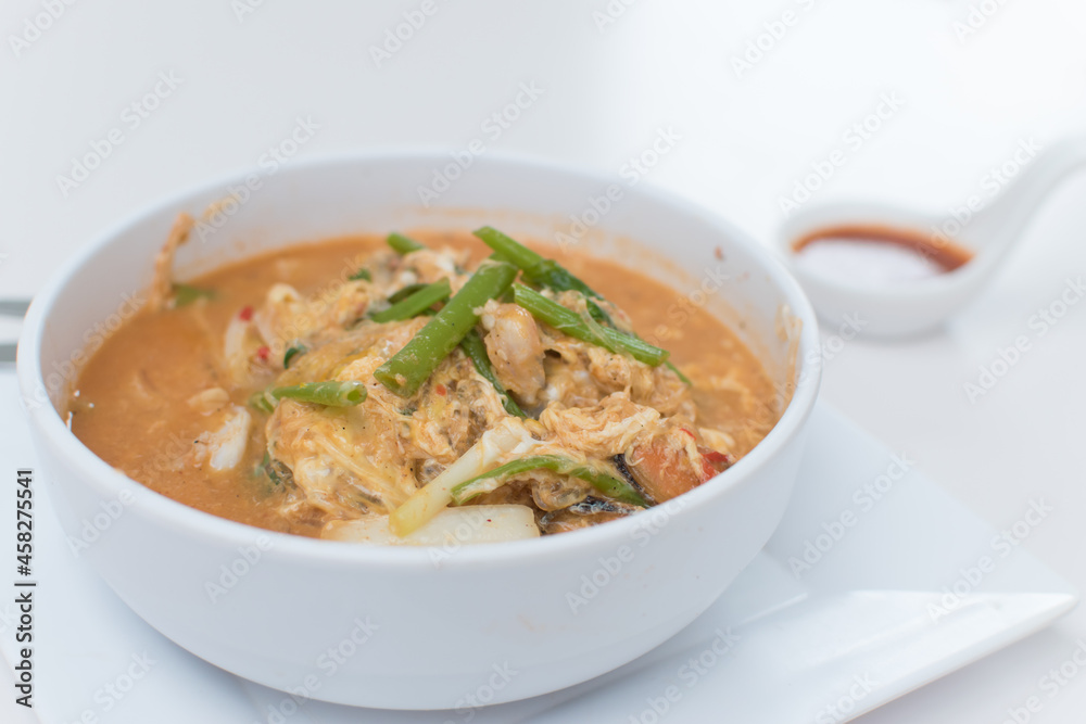Sukiyaki, in a white cup, sits on the table. Sukiyaki, in a white cup, sits on the table.