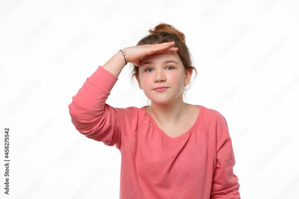 Portrait of a curious young girl looking far away with hand at her forehead, trying to see something far away Portrait of a curious young girl looking far away with hand at her forehead, trying to see something far away