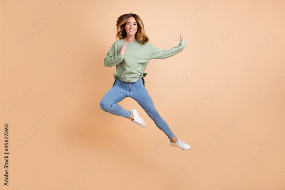 Full length body size photo woman jumping high got karate training isolated pastel beige color background