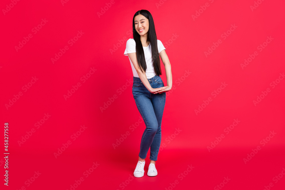 Full length photo of young attractive cheerful korean girl happy positive smile isolated over red color background Full length photo of young attractive cheerful korean girl happy positive smile isolated over red color background