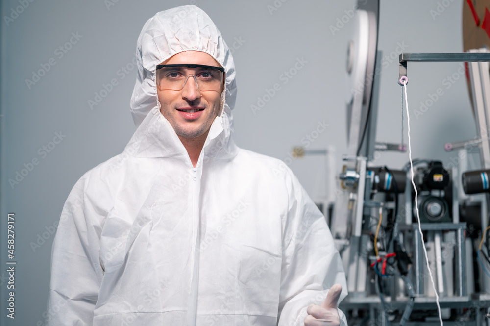 Scientists wearing protective clothing Inspect mask making machines in a laboratory at an industrial plant. Anti-virus production warehouse. concept of safety and prevention coronavirus covid-19. Scientists wearing protective clothing Inspect mask making machines in a laboratory at an industrial plant. Anti-virus production warehouse. concept of safety and prevention coronavirus covid-19.