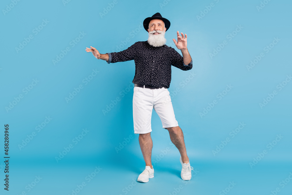 Full size photo of dreamy happy positive old man look empty space dance enjoy isolated on blue color background Full size photo of dreamy happy positive old man look empty space dance enjoy isolated on blue color background