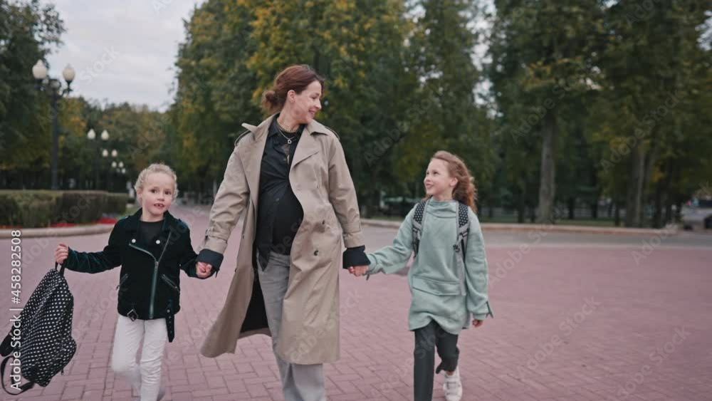 mom escorts her little daughters to school. happy family kid dream school concept. schoolgirl hurrying class for lesson to school. kid and mom lifestyle goodbye before school. High quality 4k footage mom escorts her little daughters to school. happy family kid dream school concept. schoolgirl hurrying class for lesson to school. kid and mom lifestyle goodbye before school. High quality 4k footage
