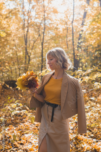 Portrait of beautiful young woman walking outdoors in autumn. Fall season and stylish girl concept.