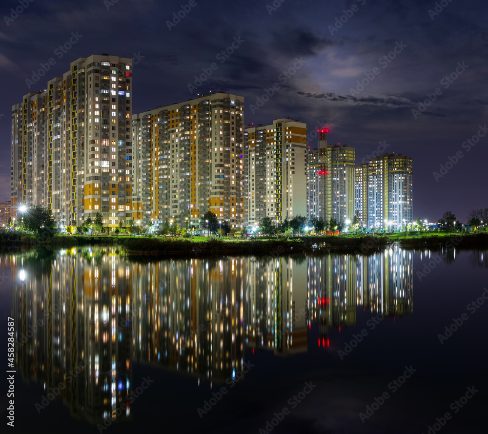 A modern night metropolis with a reflection over the lake