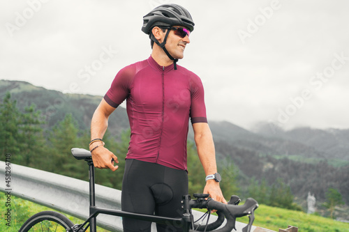 Smiling bicyclist in protective helmet on bike on roadway