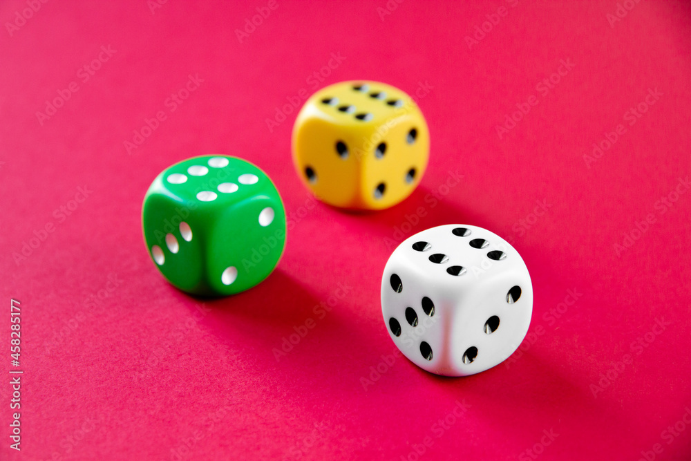 Three colorful dices isolated on pink background Three colorful dices isolated on pink background