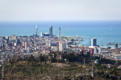 BATUMI, GEORGIA: Aerial scenic view of Batumi city center with skyscrapers and old houses with mountains in the background 