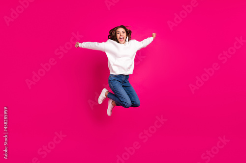 Full body photo of young excited girl happy positive smile jump up active isolated over pink color background