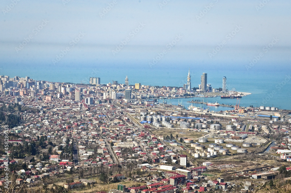 BATUMI, GEORGIA: Aerial scenic view of Batumi city center with skyscrapers and old houses with mountains in the background BATUMI, GEORGIA: Aerial scenic view of Batumi city center with skyscrapers and old houses with mountains in the background
