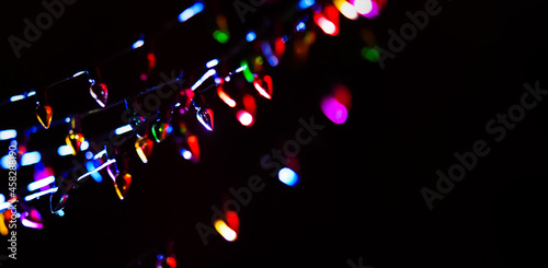 Christmas lights on dark background with copy space. Decorative garland, xmas