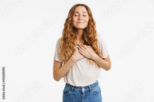 Young ginger woman smiling and holding hands on her chest