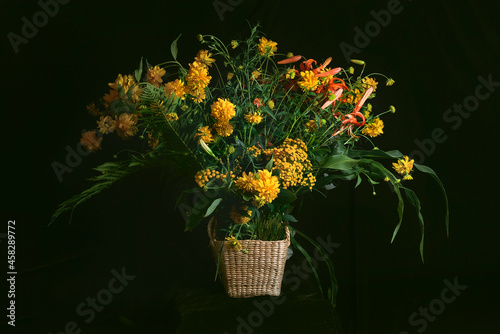 Fototapeta Naklejka Na Ścianę i Meble -  A fancy bouquet of yellow wildflowers with lilies on a dark background. Still-life. In the style of ancient Dutch masters. Large format for printing paintings in the interior