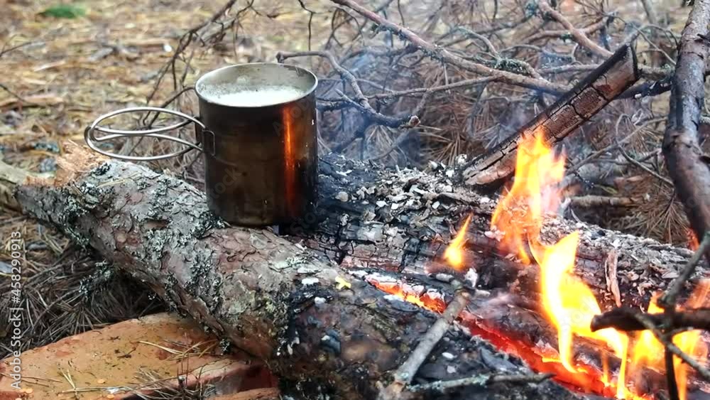 cooking hiking food on a campfire in a metal mug cooking hiking food on a campfire in a metal mug