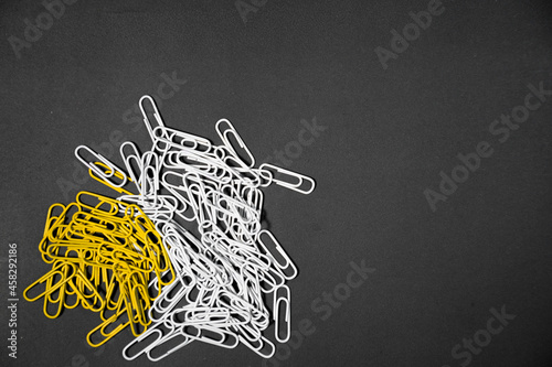 yellow and white paperclip isolated on black background