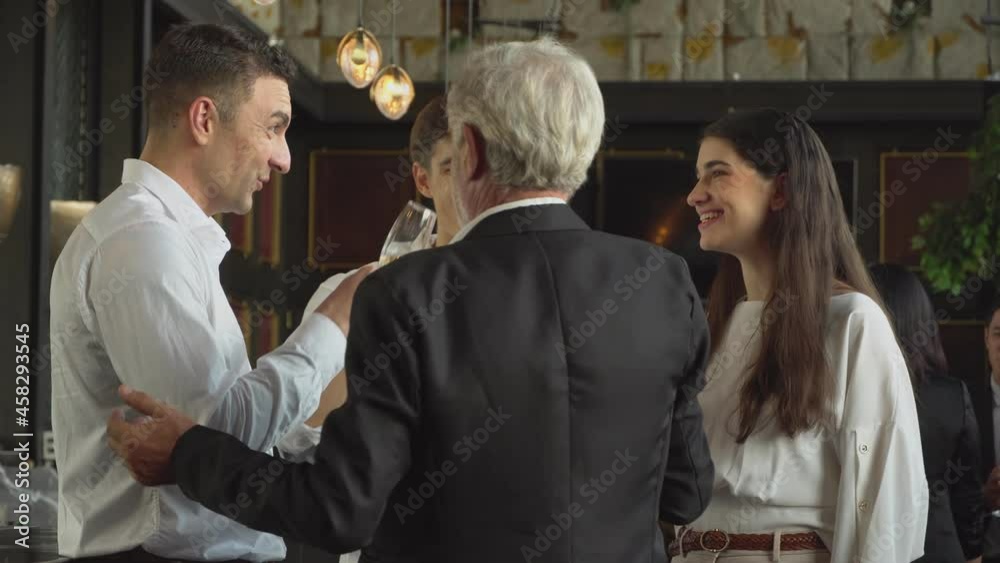 Senior boss toasting glass with employee at company party. meeting conference event in New Year. group of people enjoy conversation together Senior boss toasting glass with employee at company party. meeting conference event in New Year. group of people enjoy conversation together