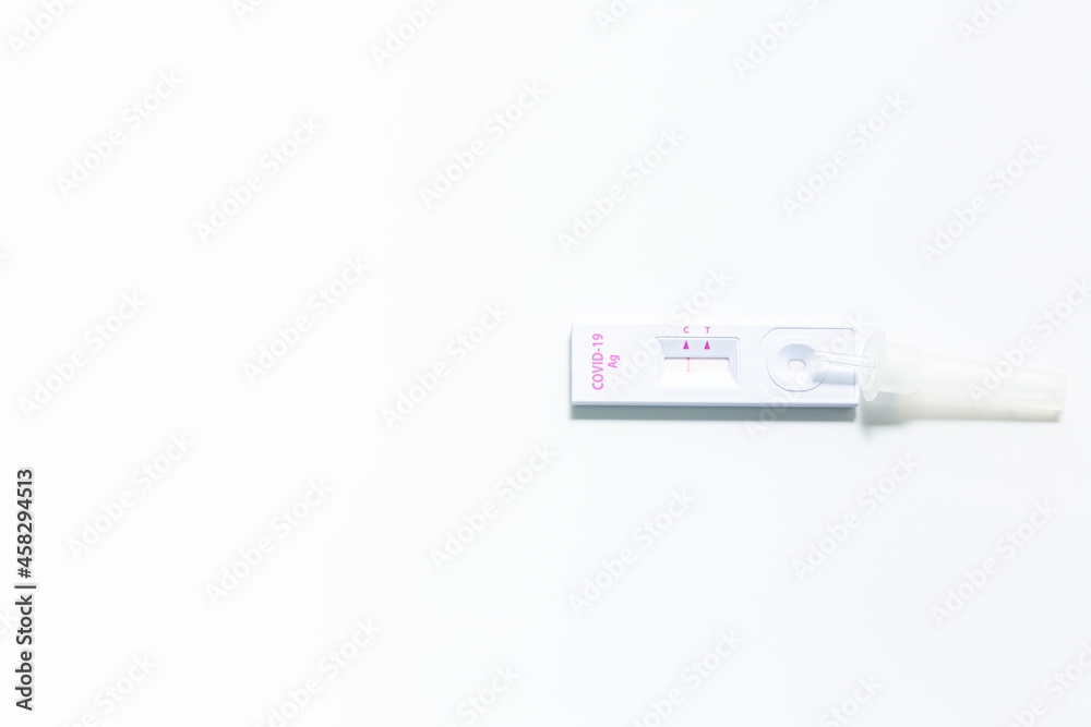 Rapid antigen self test kit for Covid-19 diagnostic at home with nasal swabs, tubes, detection device and a ffp-2 face mask, light gray background, copy space, view from above, selected focus Rapid antigen self test kit for Covid-19 diagnostic at home with nasal swabs, tubes, detection device and a ffp-2 face mask, light gray background, copy space, view from above, selected focus