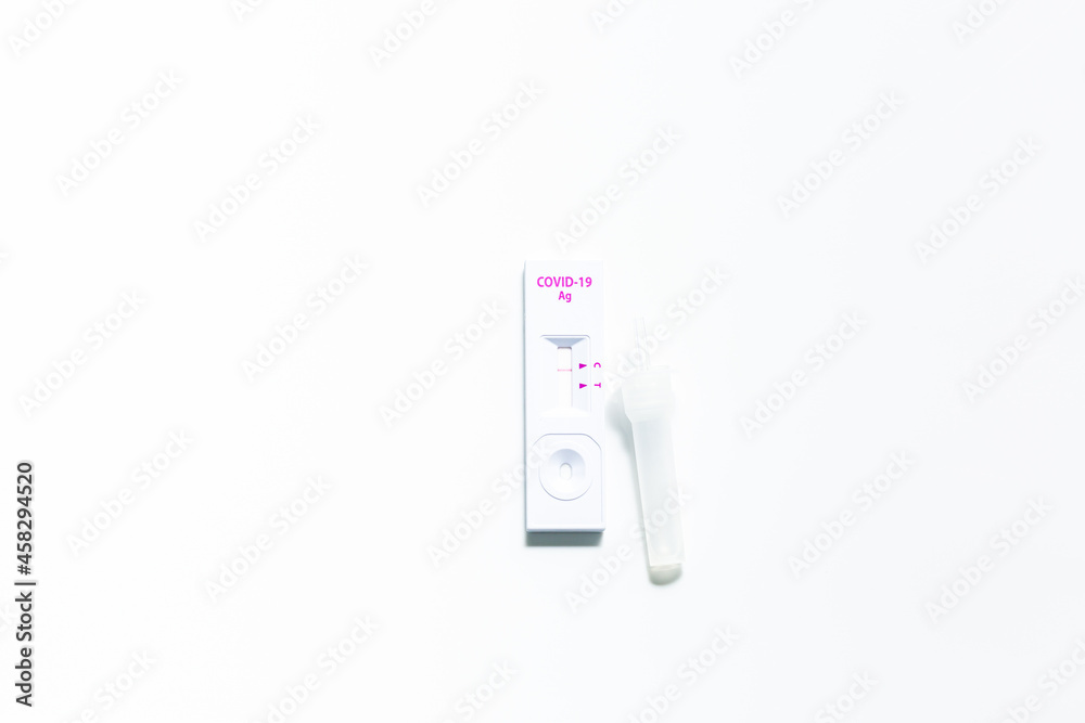 Rapid antigen self test kit for Covid-19 diagnostic at home with nasal swabs, tubes, detection device and a ffp-2 face mask, light gray background, copy space, view from above, selected focus Rapid antigen self test kit for Covid-19 diagnostic at home with nasal swabs, tubes, detection device and a ffp-2 face mask, light gray background, copy space, view from above, selected focus