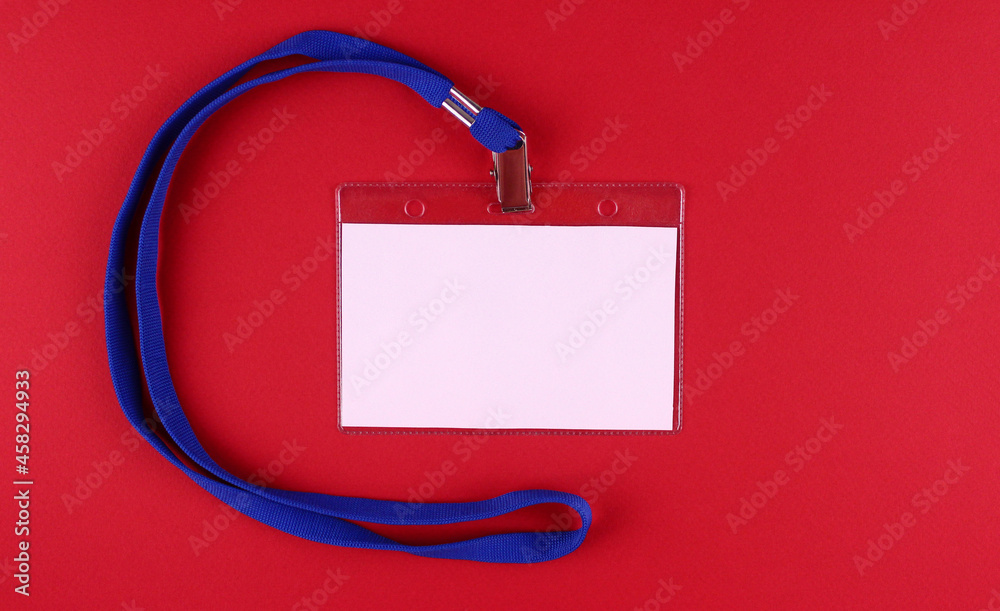 Blank horizontal white badge with blue tie on red background Blank horizontal white badge with blue tie on red background