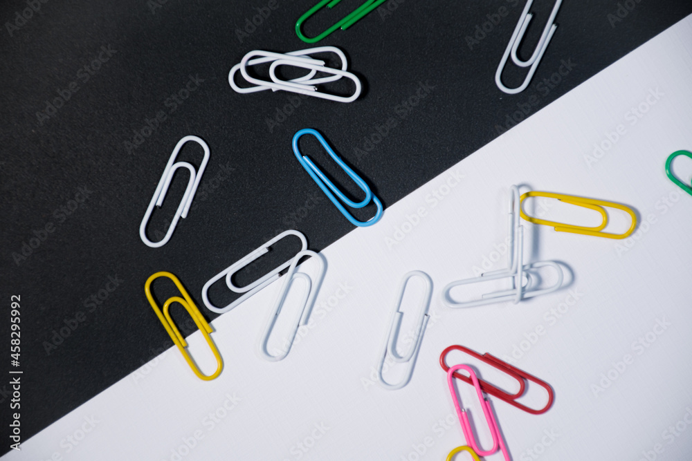 Top view of colorful paper clips on Black and white background