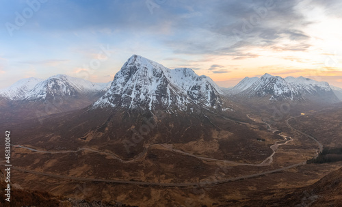 Epic, awe-inspiring panorama mountain landscape view from Stob Beinn a'Chrulaiste, of a snowcapped Buachalle Etive Mor at sunset or sunrise in Glencoe, Scottish Highalnds