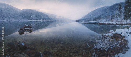 Beautiful mountain and lake winter panorama landscape of calm reflection on Kootenay Lake with sunrise or sunset light and mist in Nelson, British Columbia, Canada. photo