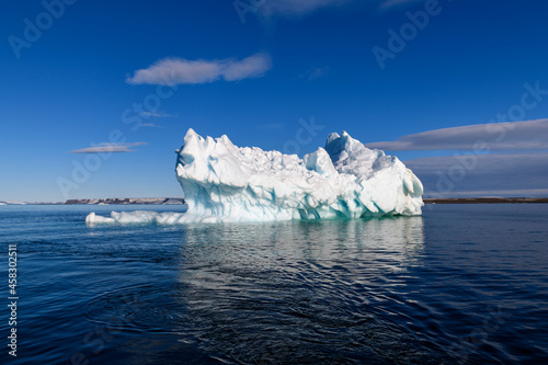 Beautiful iceberg in Arctic sea at sunny day. Big piece of ice in sea close up.