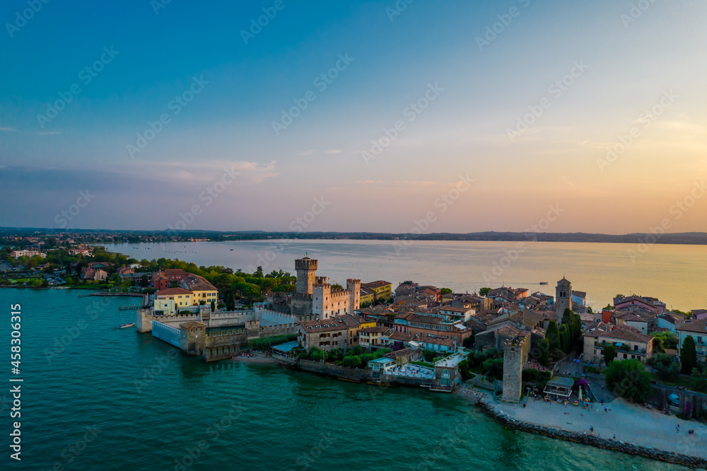 Aerial panoramic view of Sirmione city old town on lake Garda in Lombardy, Italy. Evening photo with a castle in a center