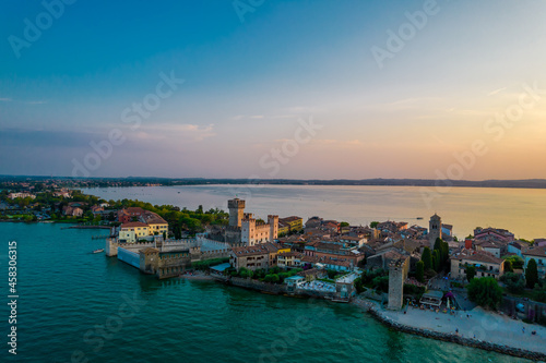 Aerial panoramic view of Sirmione city old town on lake Garda in Lombardy, Italy. Evening photo with a castle in a center