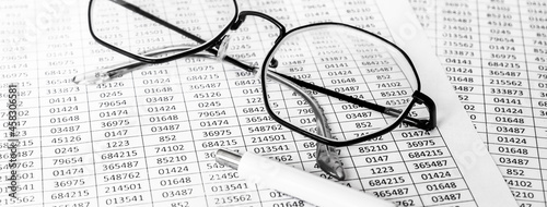 finance business calculation with glasses  tables with numbers and pen. business concept. financial literacy. accounting of income and expenses. background banner