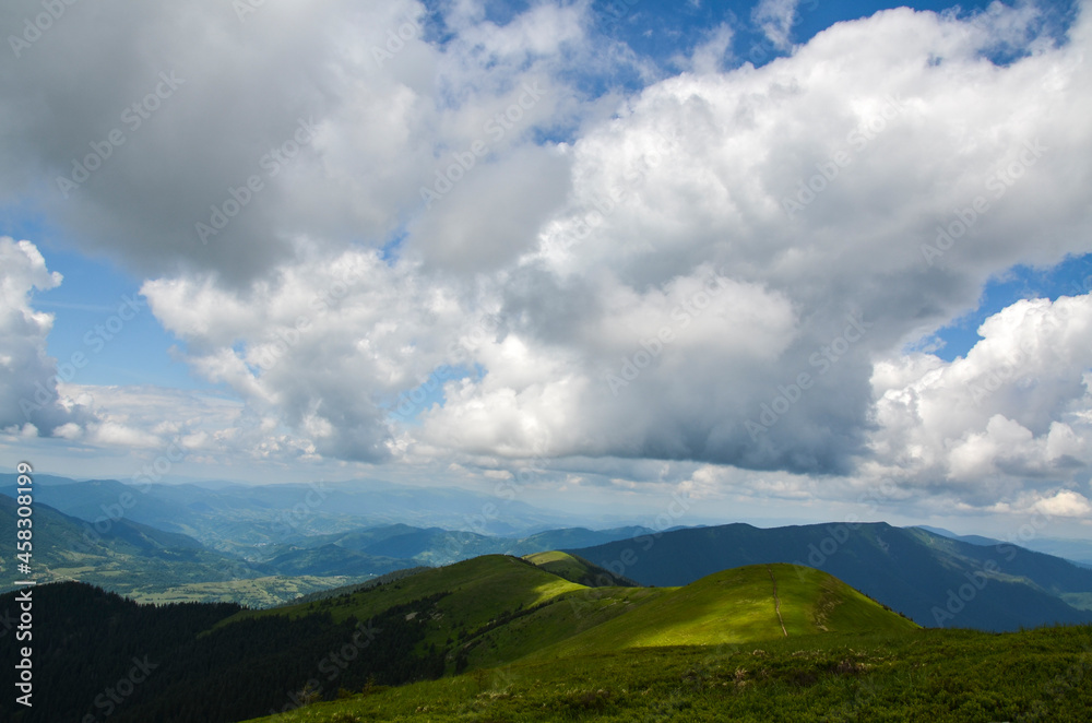 Beautiful scene, with mountain peaks covered green lush grass under cloudy sky. Classic Carpathian mountains landscape in summer