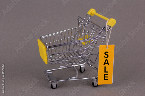 Empty small shopping cart with yellow tag "sale"