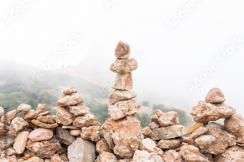 Stones stacked in pile in foggy highland photo