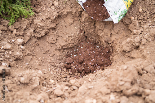 Fertile soil in pit among dry land photo