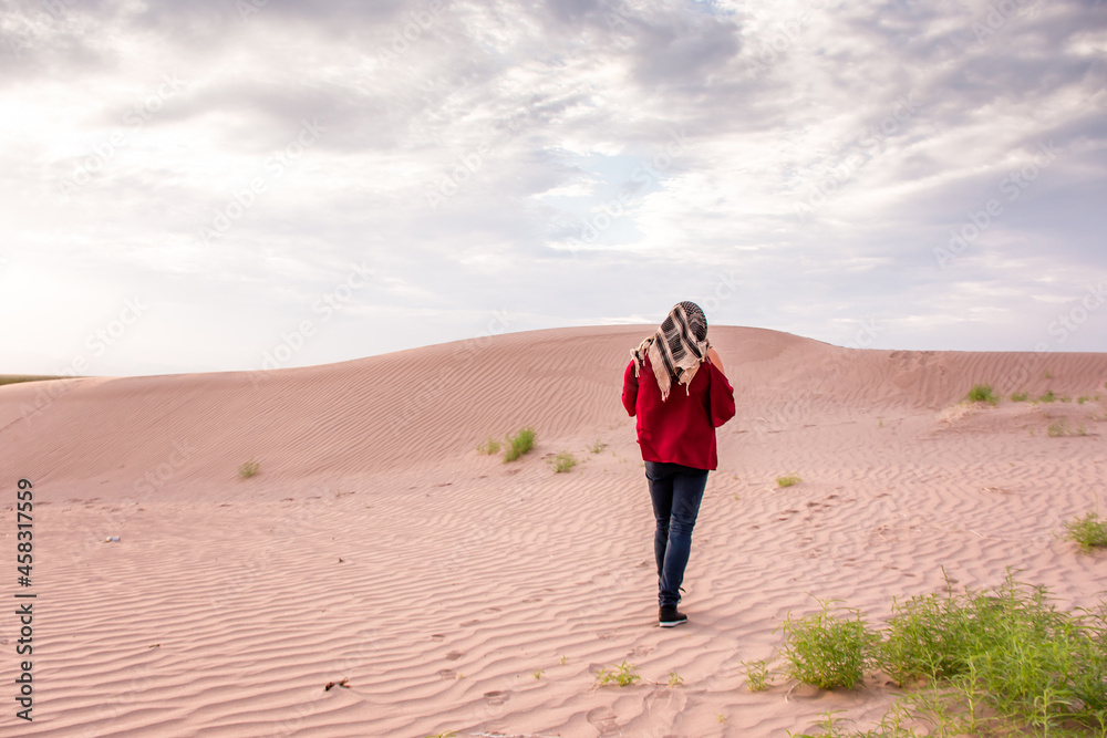 Woman walking on desert dunes