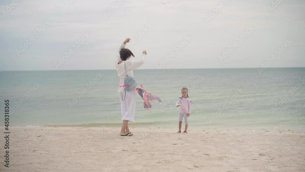 Mother with Little Daughter Dressed White Clothes Playing Kite Sea Beach Happy Caucasian Family With One Child Have Fun Summer Vacation Sea Shore. Active Leisure Positive Emotions Happy Childhood Mother with Little Daughter Dressed White Clothes Playing Kite Sea Beach Happy Caucasian Family With One Child Have Fun Summer Vacation Sea Shore. Active Leisure Positive Emotions Happy Childhood