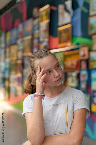 A girl in a museum of arts at an exhibition of painting against the backdrop of an art gallery.