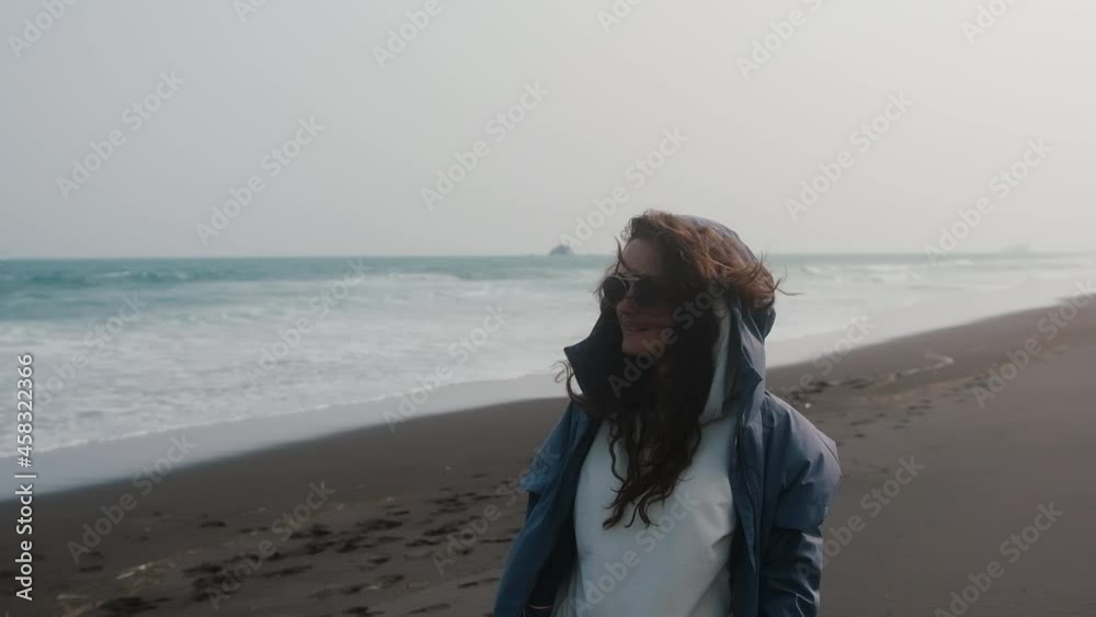 Beautiful girl enjoying the wet wind on the beach. Carefree European young woman smiling with the ocean in the background. Beautiful girl enjoying the wet wind on the beach. Carefree European young woman smiling with the ocean in the background.
