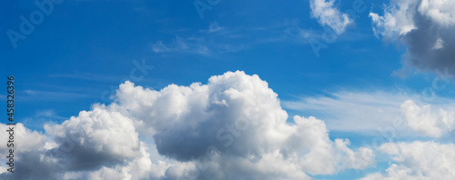 Fotografie White cumulus clouds in the blue sky on a sunny day